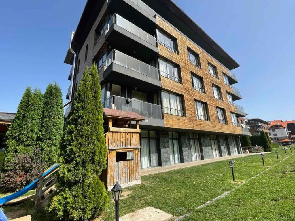 an apartment building with a wooden facade at Charming comfortable apartment at Cornelia Deluxe Residence with free pool and SPA in Razlog