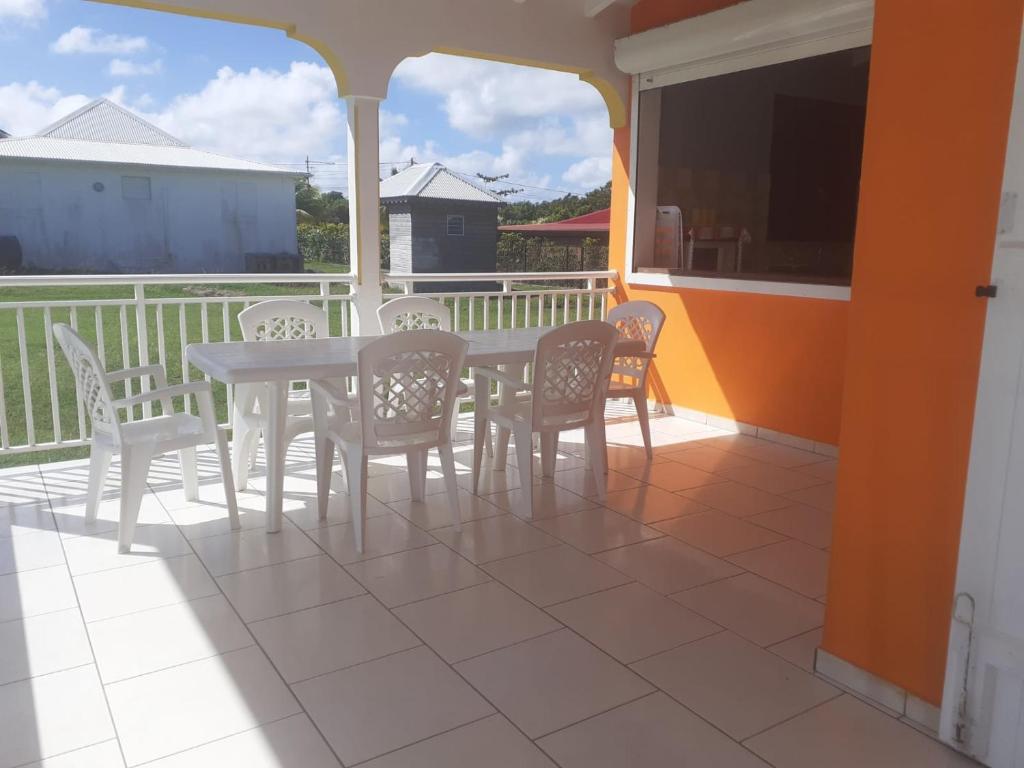 a porch with a table and chairs on a balcony at Villa le vent du nord in Capesterre