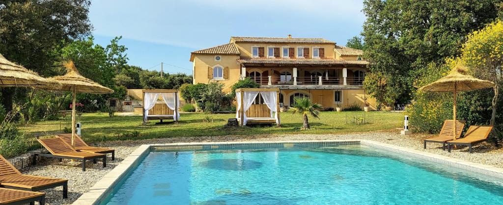 uma grande piscina em frente a uma casa em Appartement 5 personnes - Mas du Soleil em Bagnols-sur-Cèze