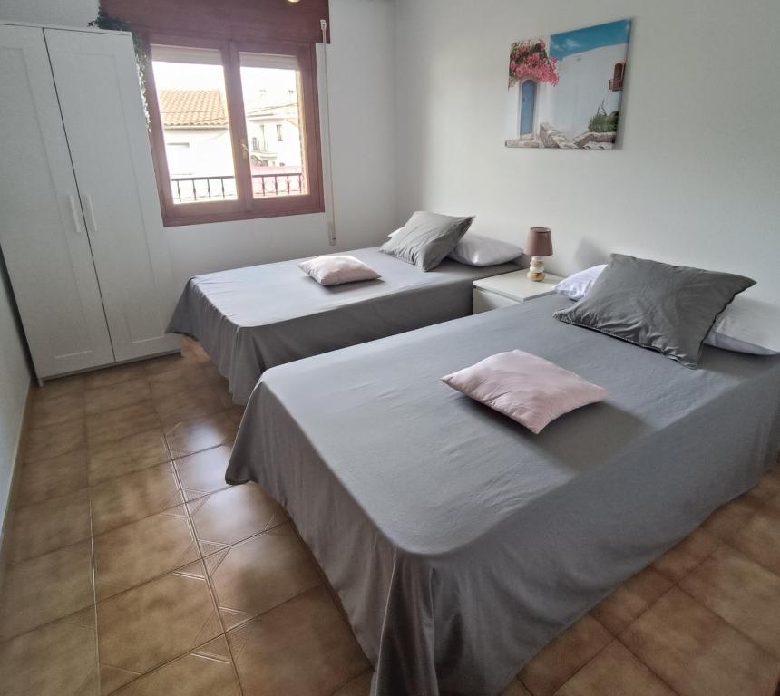 two beds in a room with two windows at Casa Verilia in Olombrada