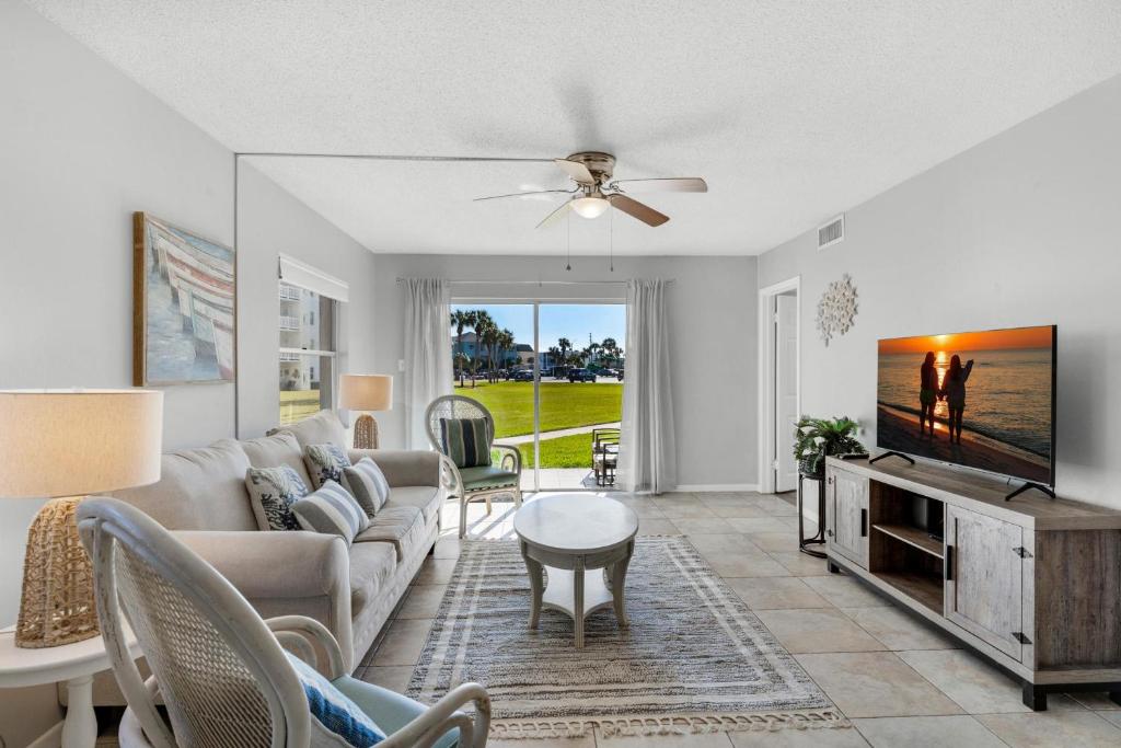 a living room with a couch and a tv at El Matador- Beachside Haven 210 in Fort Walton Beach