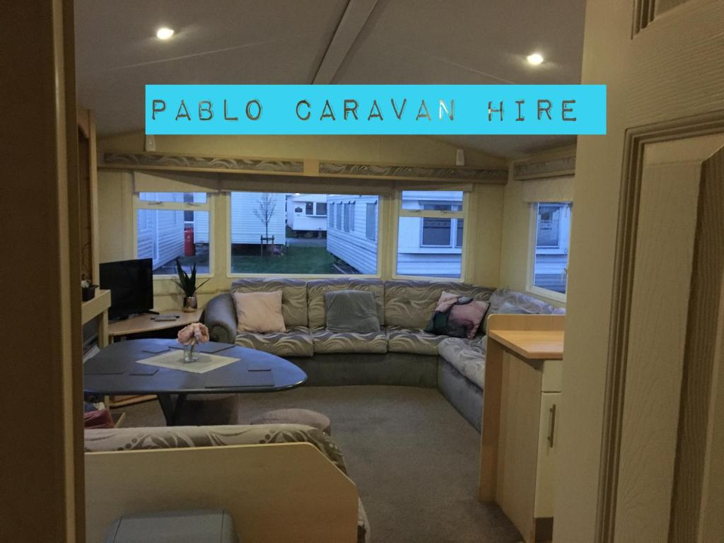 sala de estar con sofá y mesa en 2 bedroom 6 berth Caravan Towyn Rhyl en Kinmel Bay