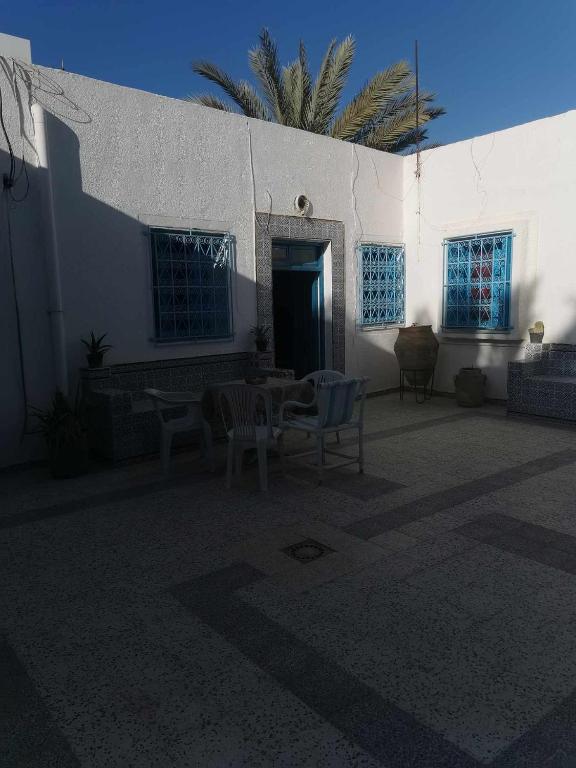 a patio with a table and chairs in front of a building at Dar arbi in Houmt Souk