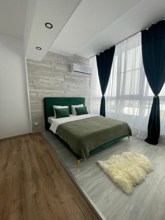 a bedroom with a large bed and a rug at Marisah Residence #3 in Otopeni