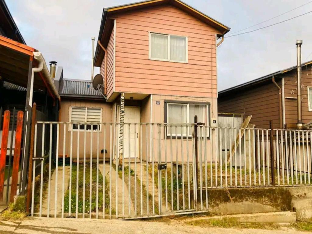 a house with a fence in front of it at Casa con buena ubicación estacionamiento gratuito in Castro