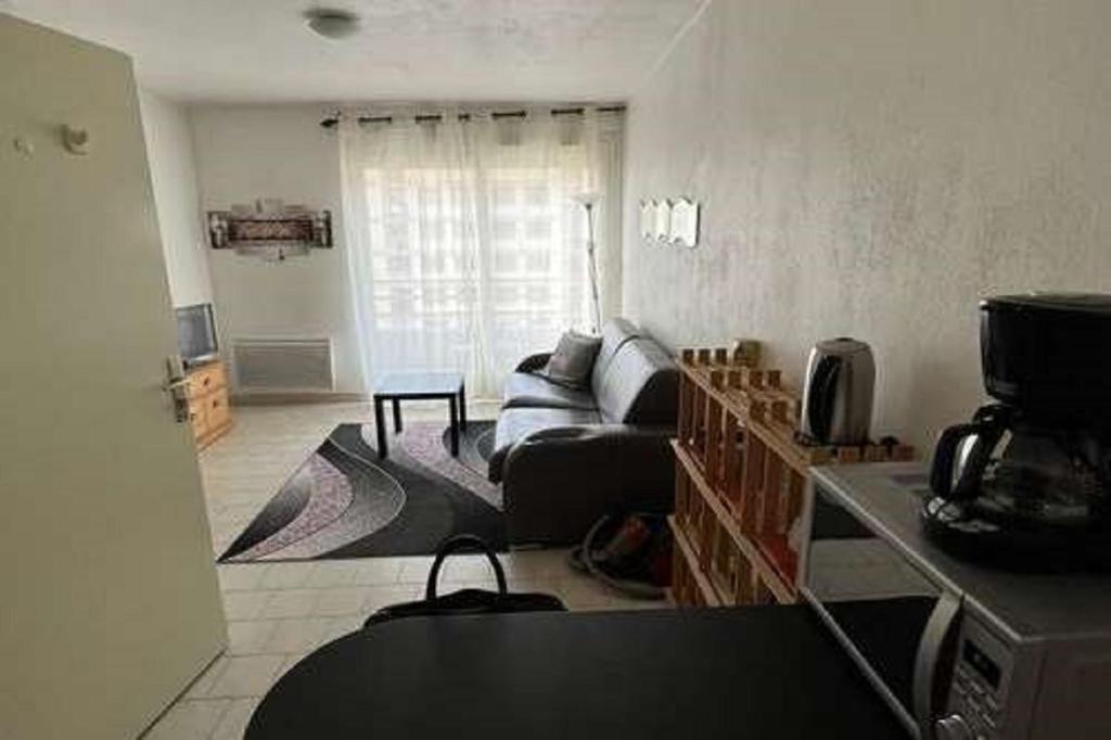uma sala de estar com um sofá e uma mesa em Beau studio , ensoleillé, Wifi, etage 5 ascenceur em Marselha