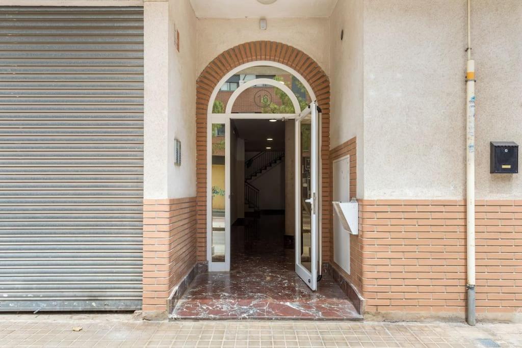 una entrada a un edificio con una puerta abierta en Precioso piso en Catarroja
