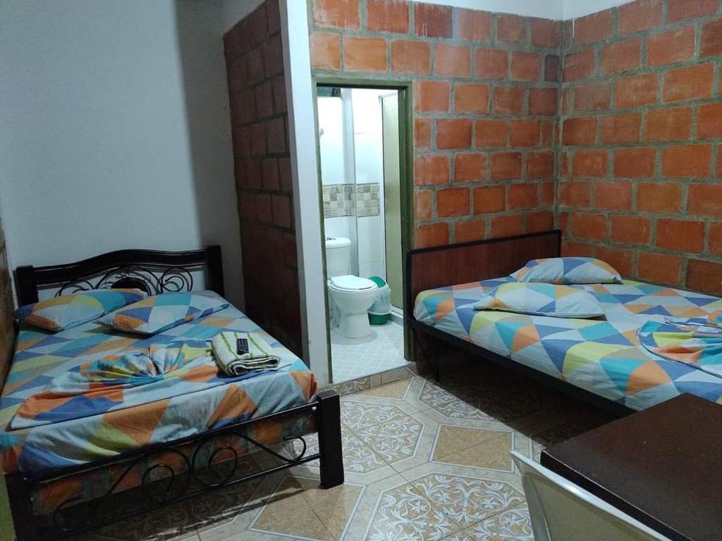 a bedroom with two beds and a mirror at Hospedaje la Viña in El Cerrito