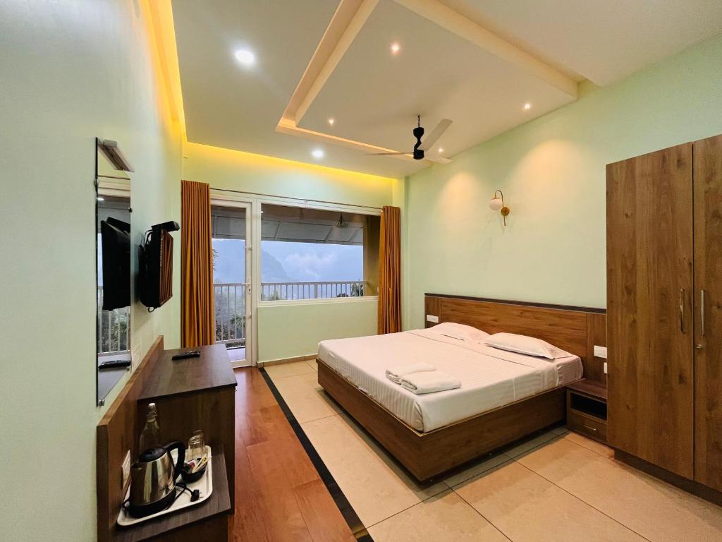 1 dormitorio con 1 cama y TV en EDENS SNOW CASTLE en Anachal