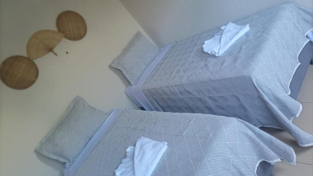 three beds with pillows on a white floor withthritisthritisthritisthritisthritisthritis at Pousada Dboa Milagres in São Miguel dos Milagres