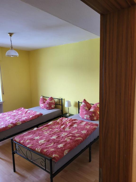 two beds in a room with yellow walls at Gemeinschaft Ferienhaus in Bad Neuenahr-Ahrweiler