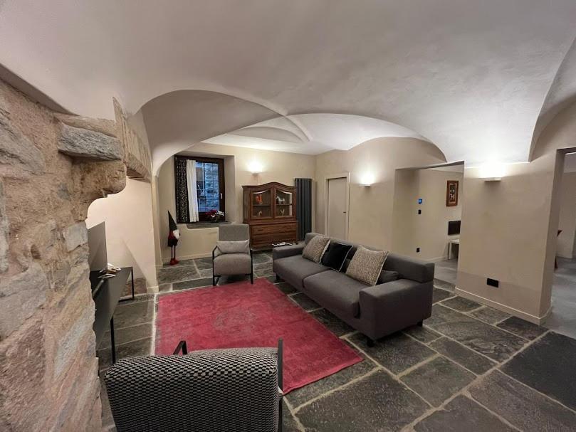 - un salon avec un canapé et un tapis rouge dans l'établissement Casa di Sant'Anselmo - La Corte - CIR VDA AOSTA 0193, à Aoste