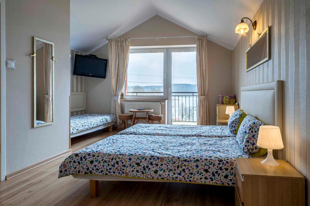Brodnica DolnaにあるPensjonat nad jeziorem Lakesideのベッドと窓が備わるホテルルーム
