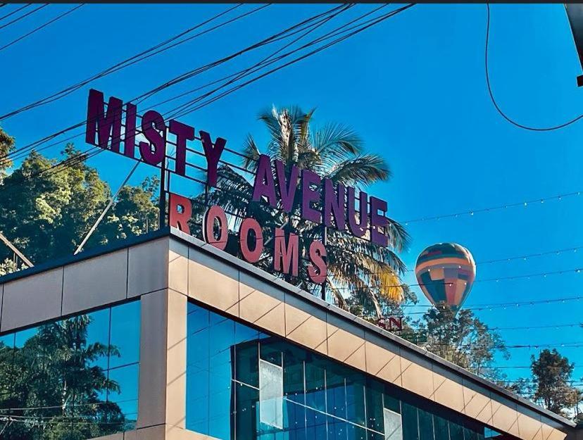 un cartel en la parte superior de un edificio con un globo de aire caliente en Misty Avenue Premium Rooms en Anachal