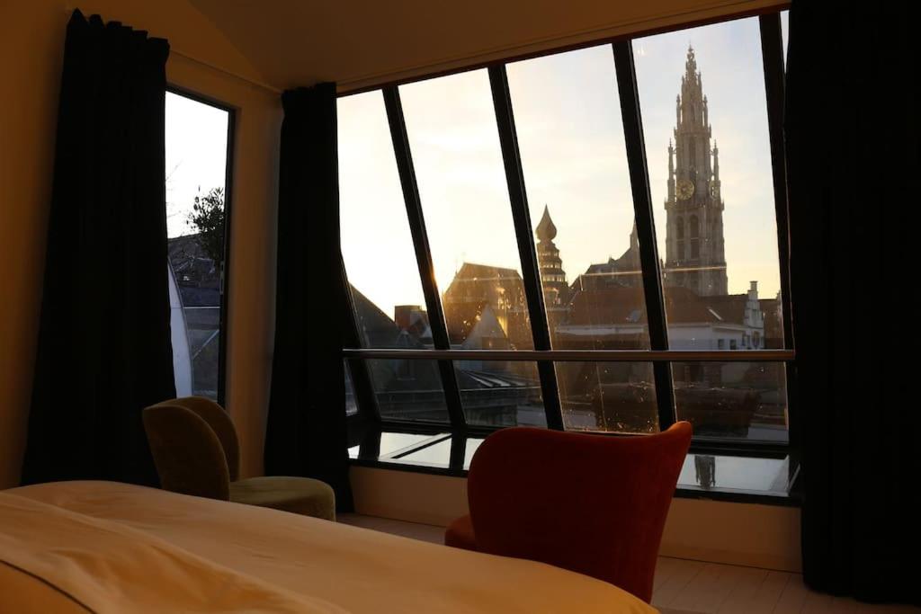 a room with a window with a view of a clock tower at The View in Antwerp