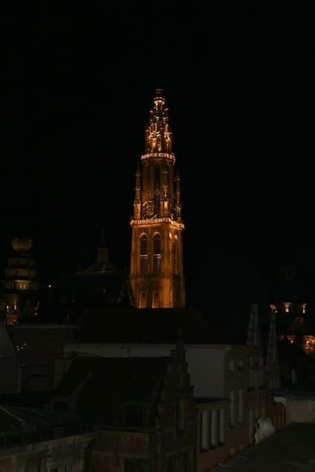 a tall clock tower at night with a building at The View in Antwerp