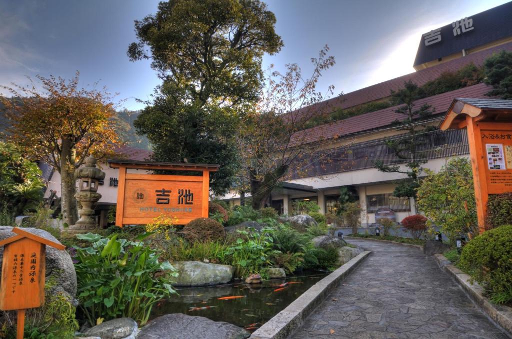einen Garten mit einem Teich vor einem Gebäude in der Unterkunft Yoshiike Ryokan in Hakone