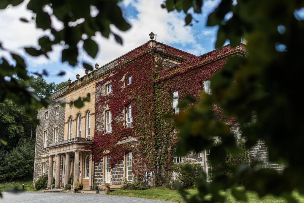 ein altes Backsteingebäude mit Efeu, der darauf wächst in der Unterkunft Plas Nanteos Mansion in Aberystwyth