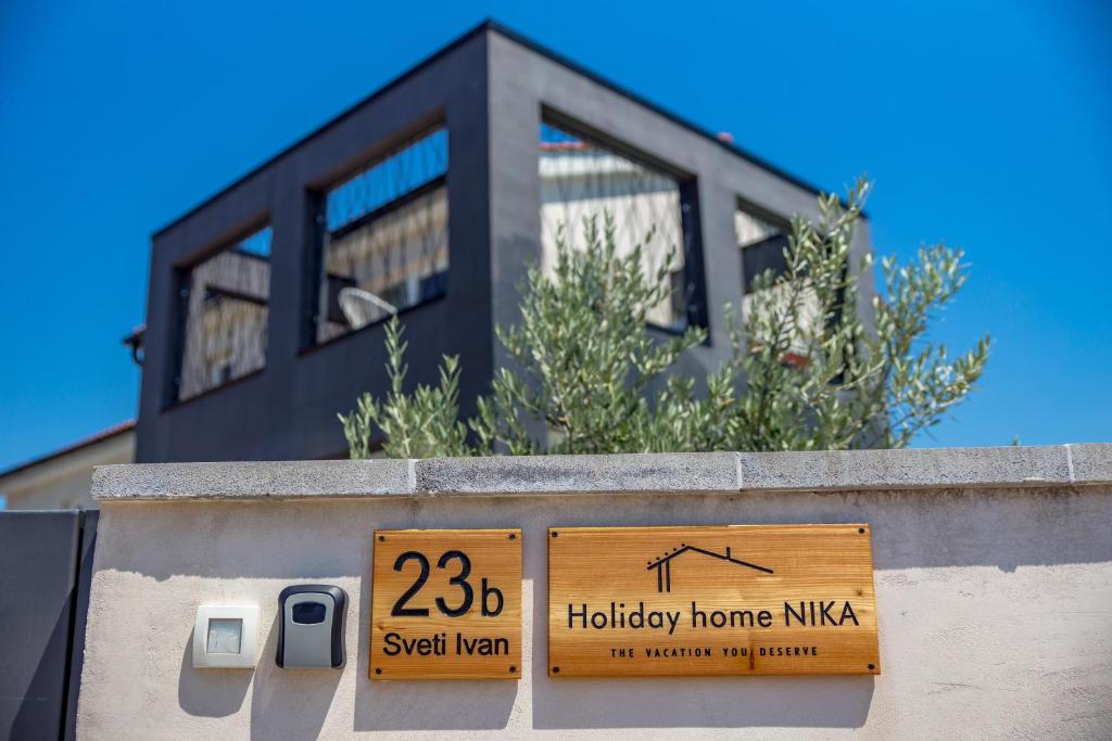 a house on top of a wall with a sign at Holiday home Nika in Sveti Ivan Dobrinjski