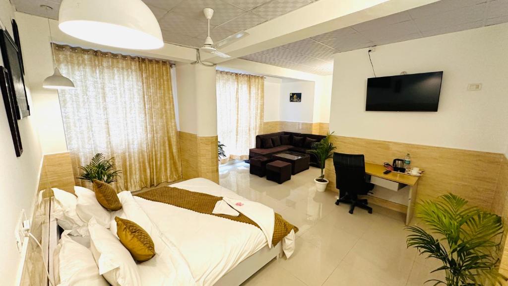 a bedroom with a bed and a desk and a couch at Hotel Relax In - Noida Sector 18 in Noida