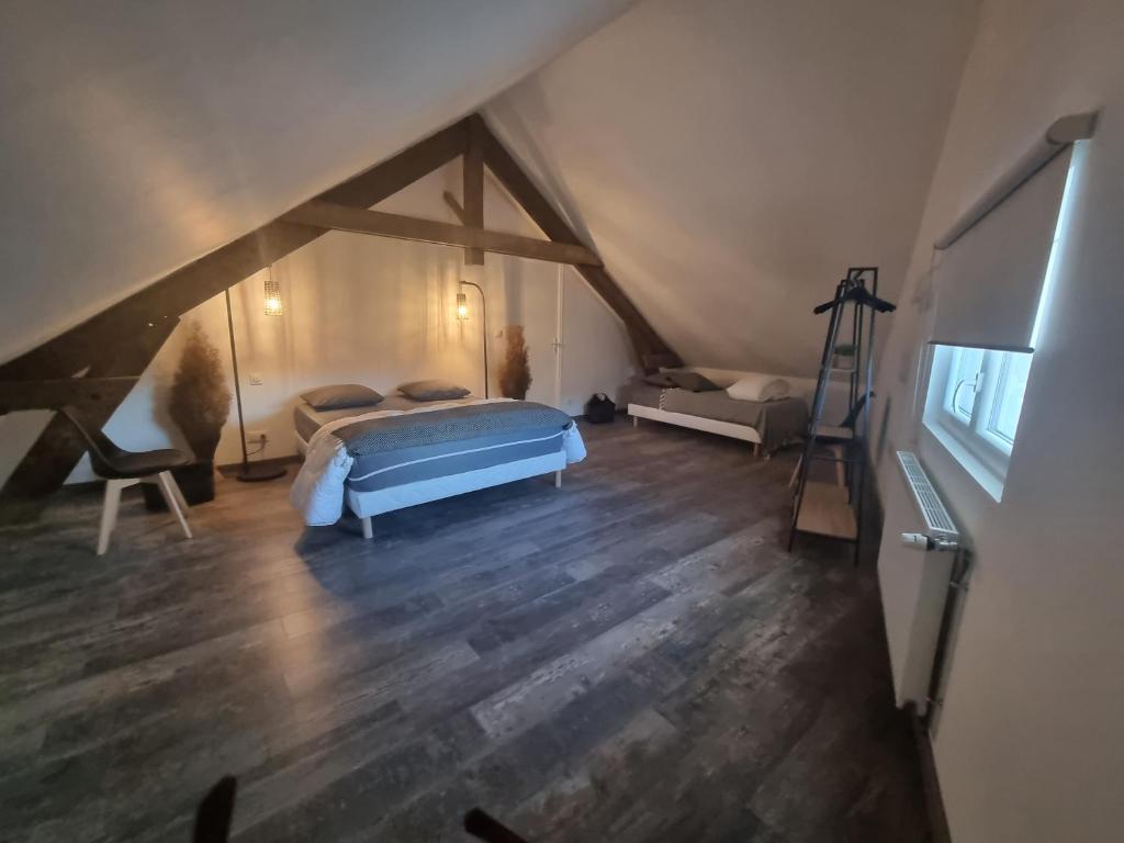 ein Schlafzimmer mit einem Bett auf einem Dachboden in der Unterkunft Échappée belle en baie de Somme in Saint-Quentin-Lamotte-Croix-au-Bailly