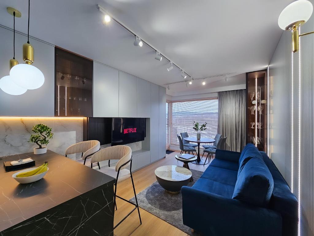 a living room with a blue couch and a table at Aurum Apartamenty Nowy Sącz Aleje Piłsudskiego 20 Bezpłatny parking! in Nowy Sącz