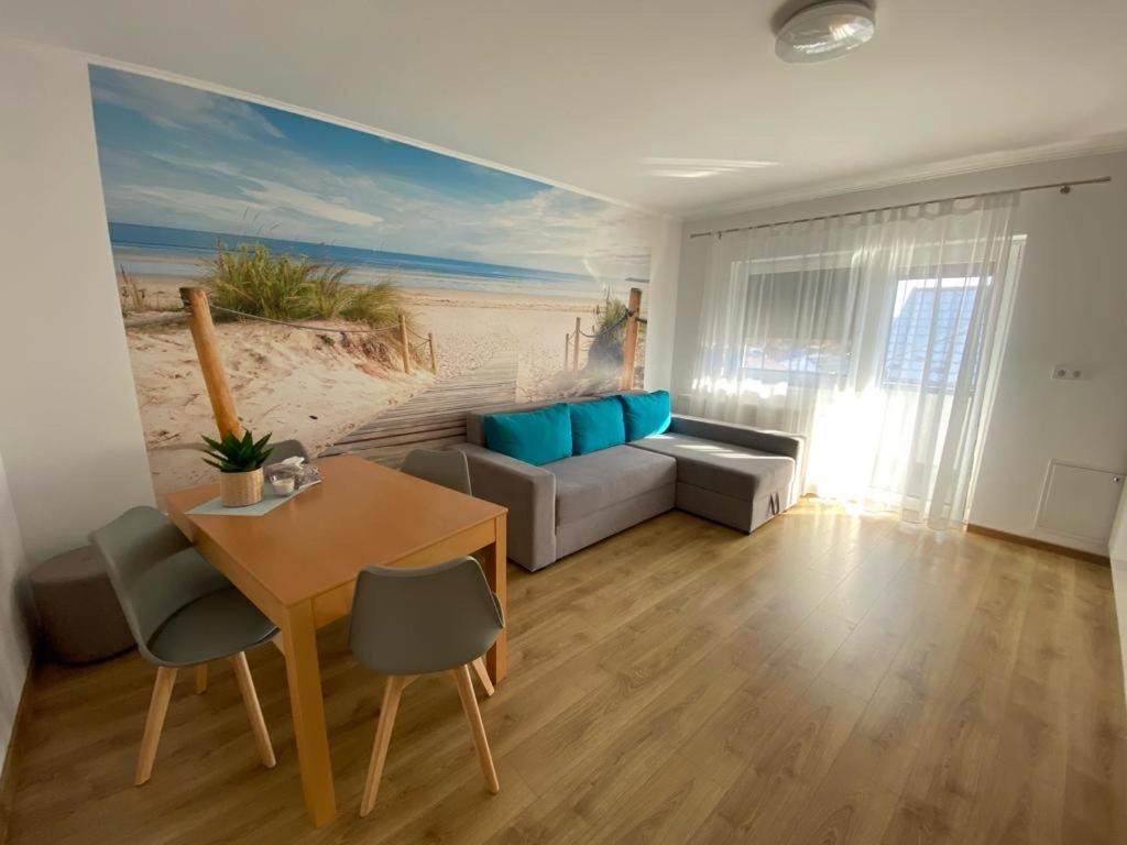 un soggiorno con divano e tavolo di Apartament NALA a Mediaş