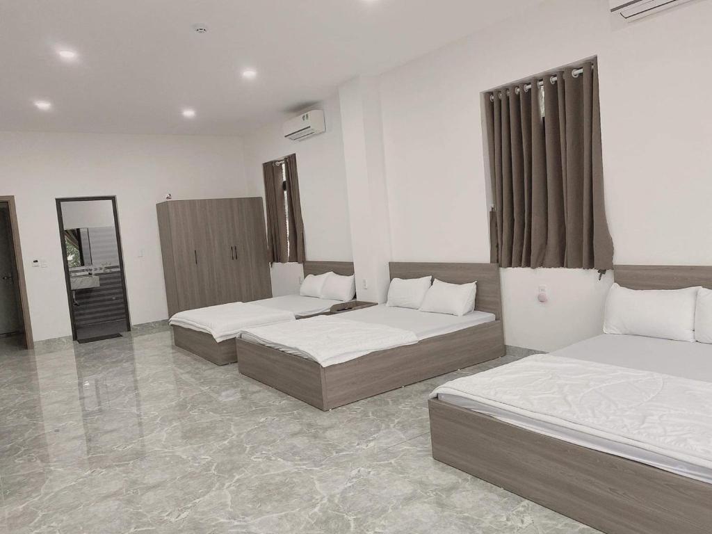 Pokój hotelowy z 2 łóżkami i lustrem w obiekcie Hotel Ngọc Phụng w mieście Ban Blech