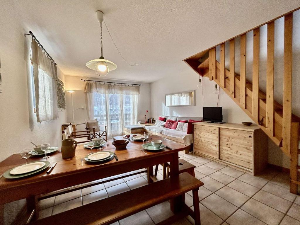 a living room with a dining table and a staircase at Appartement Le Monêtier-les-Bains, 3 pièces, 6 personnes - FR-1-330F-36 in Le Monêtier-les-Bains