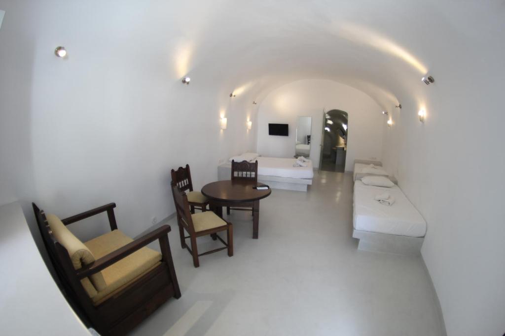 - un salon avec une table, des chaises et un canapé dans l'établissement Fira Cave Experience, à Fira