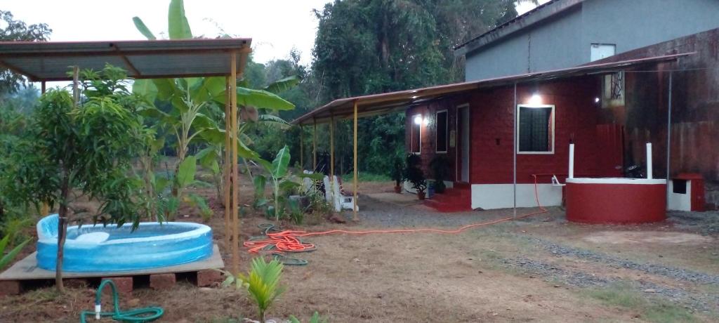 a house with a tub in front of a yard at Mendonca's Home Stay in Pernem