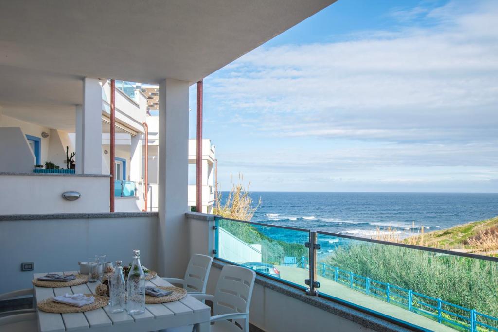 einen Balkon mit einem Tisch und Meerblick in der Unterkunft Diamante Apartments in Valledoria