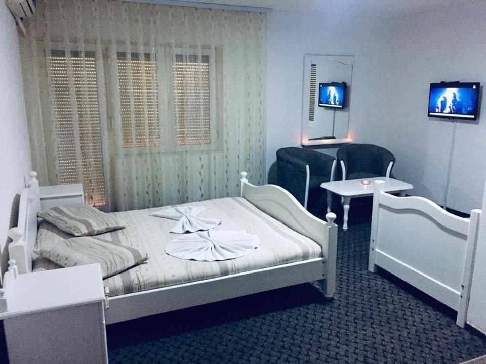 Kosovo Polje的住宿－Motel Albatros，卧室配有1张床、1张桌子和1把椅子