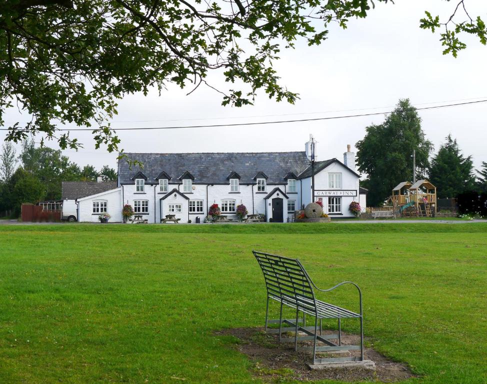 a bench sitting in the grass in front of a house at Garway Moon Inn in Garway