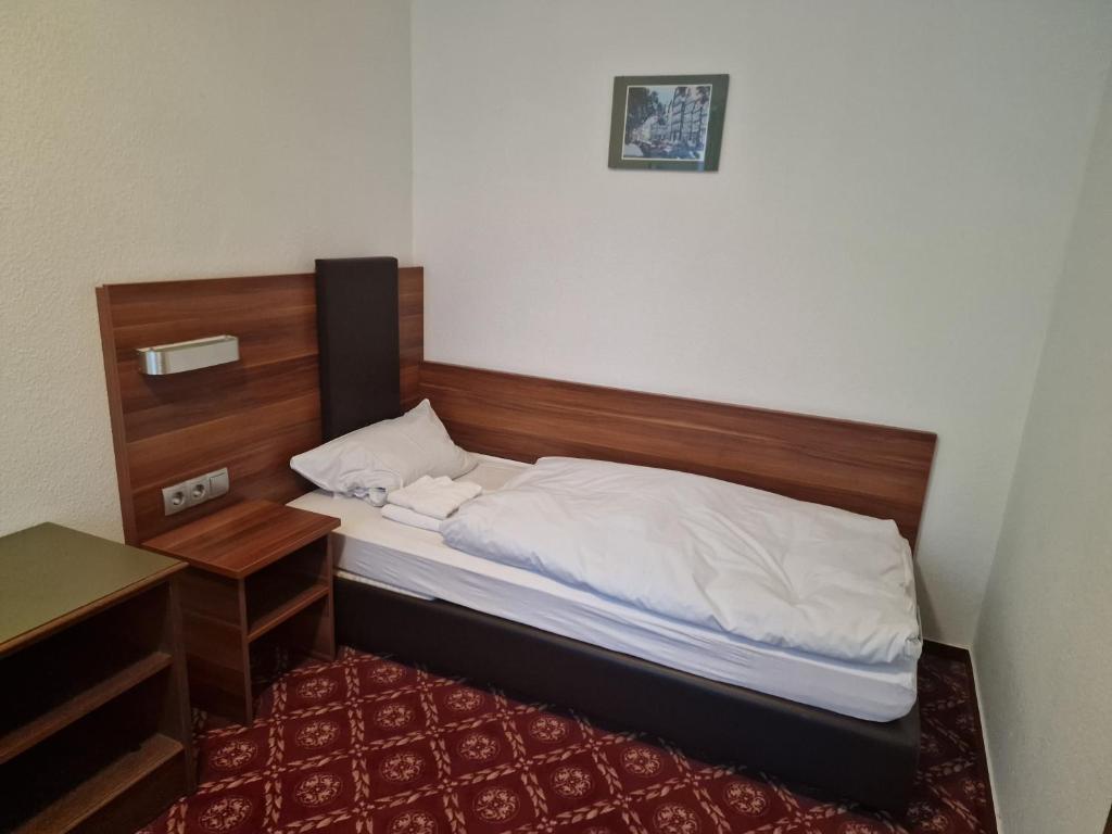 1 dormitorio con cama con cabecero de madera y escritorio en Landhotel Neding en Hauenstein