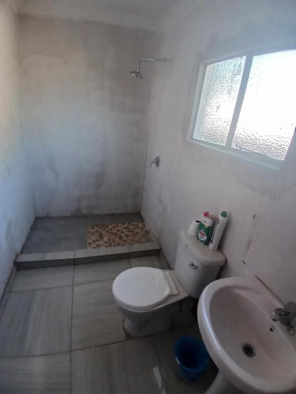 uma casa de banho com um WC, um lavatório e uma janela em Partulaka Rest Inn em Maun