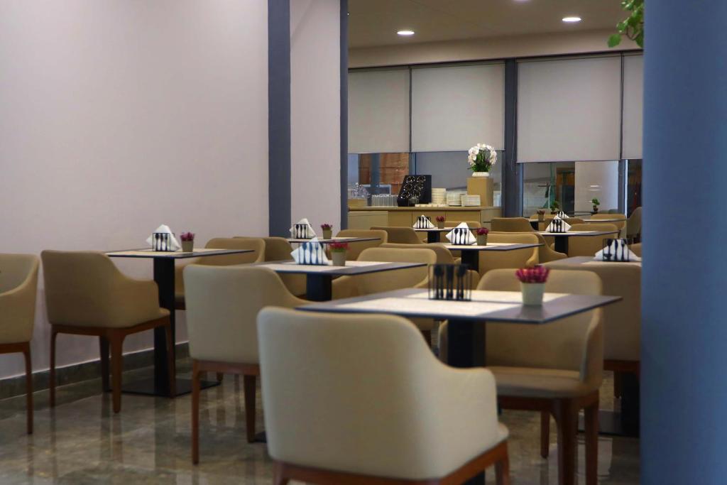 a dining room with tables and chairs in a restaurant at Metro Hotel Terminal in Tirana