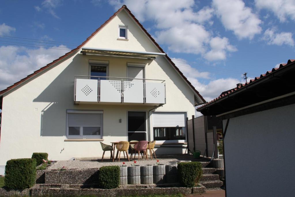 uma casa branca com cadeiras e uma varanda em Feriendomizile Menholz em Balingen