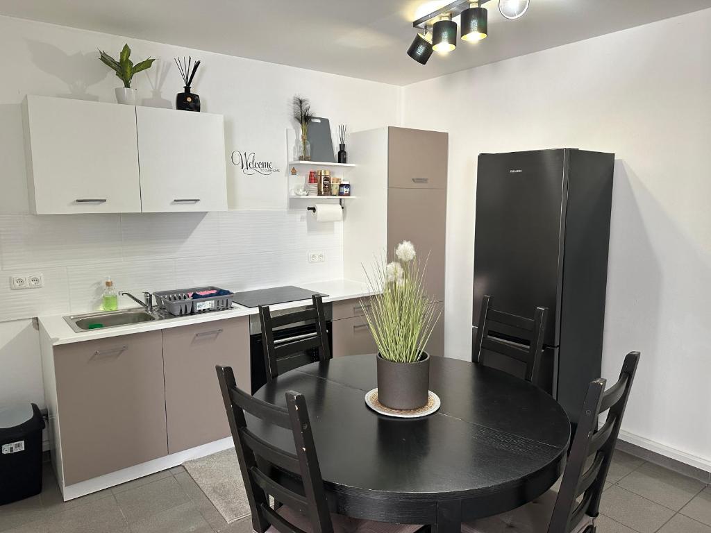 uma cozinha com uma mesa preta e um frigorífico preto em Ferienwohnung Sindorf em Kerpen