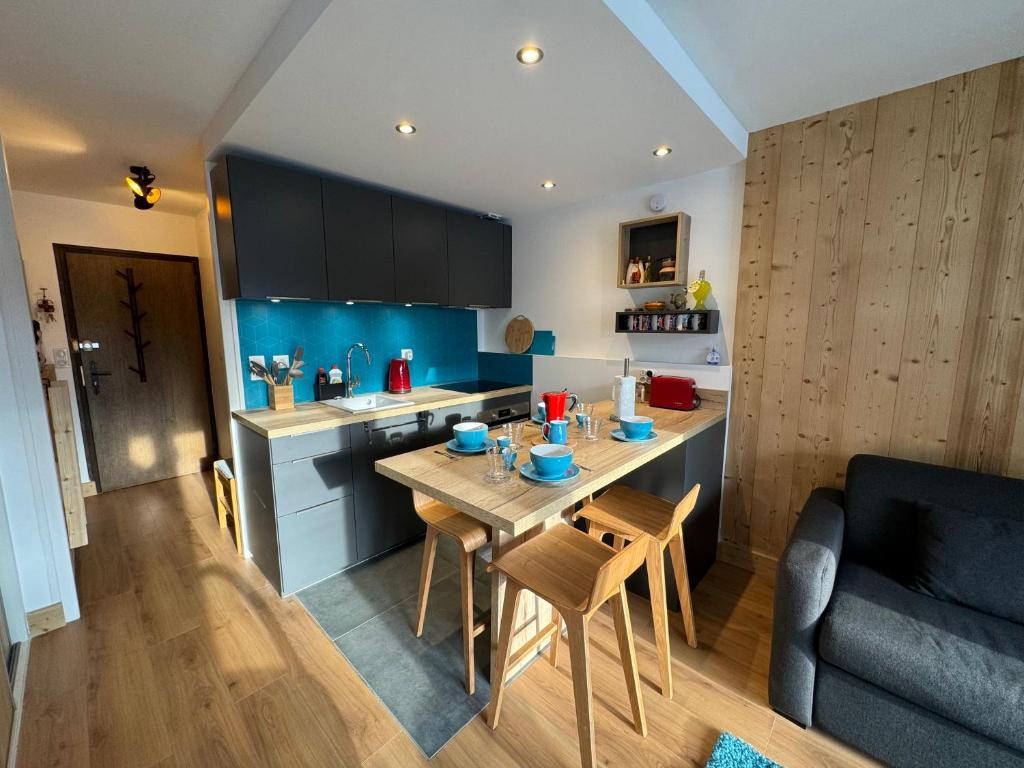 une cuisine avec une table en bois et une salle à manger dans l'établissement CHAMPS DE LA PLAGNE B10, à Morzine