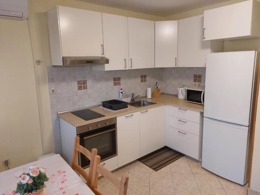 a kitchen with white cabinets and a white refrigerator at Apartment Lavanda in Split