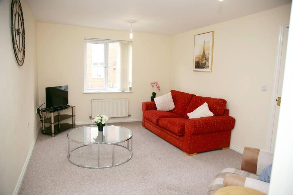 uma sala de estar com um sofá vermelho e uma mesa de vidro em Stylish beautiful Lodge in Norwich em Norwich