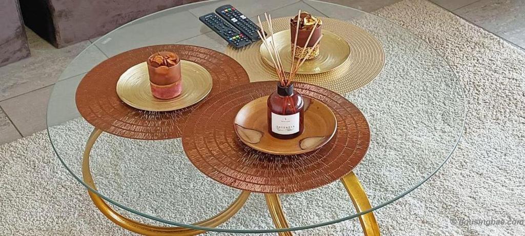 a glass table with two plates and a bottle of wine at Luxury Penthouse 3 in Yaoundé