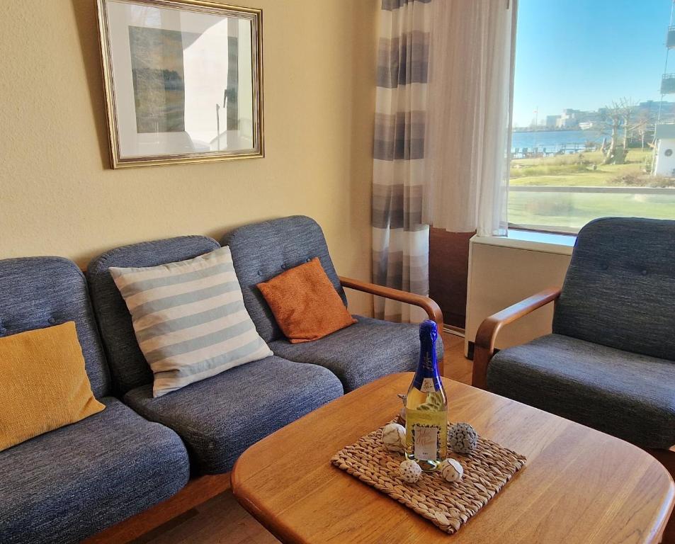 a living room with a couch and two chairs and a table at Steinwarder 1 - Haus "Seerose" ST1 018 Steinwarder 1 in Heiligenhafen