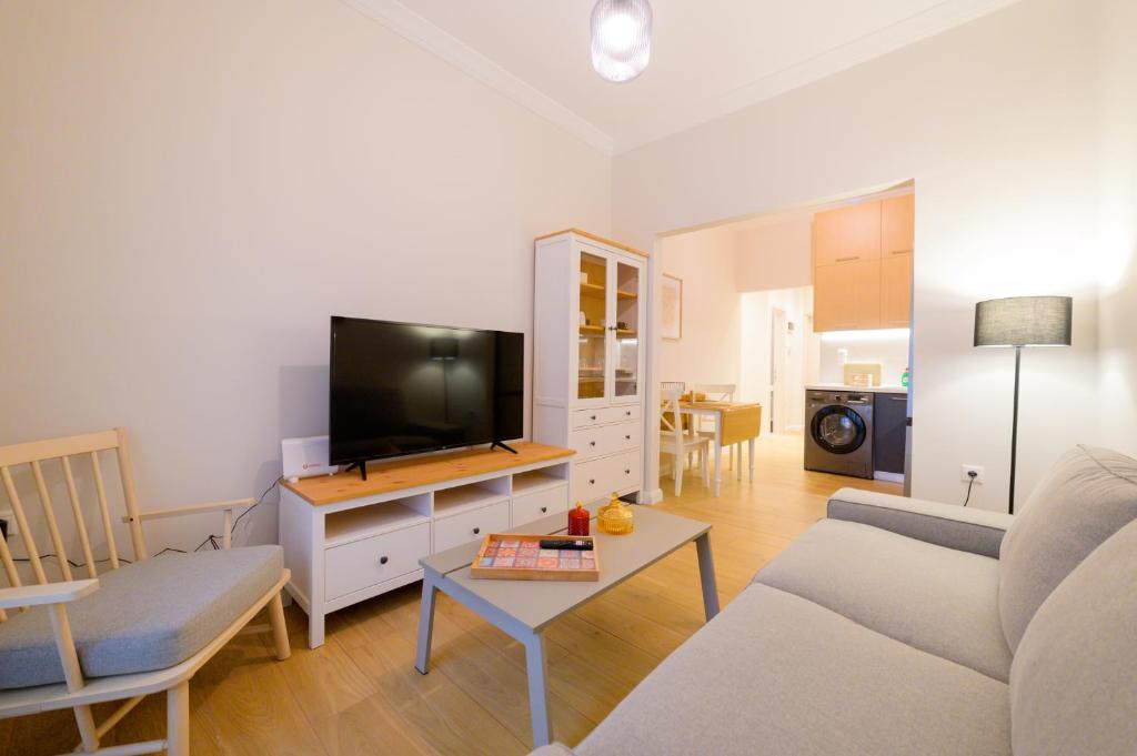 ein Wohnzimmer mit einem Sofa und einem Flachbild-TV in der Unterkunft New modern 2nd floor apartment in Thessaloniki