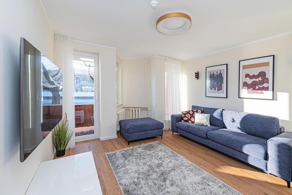 a living room with a blue couch and a tv at Riverfront 1BD Old Town Apartment by Hostlovers in Kaunas