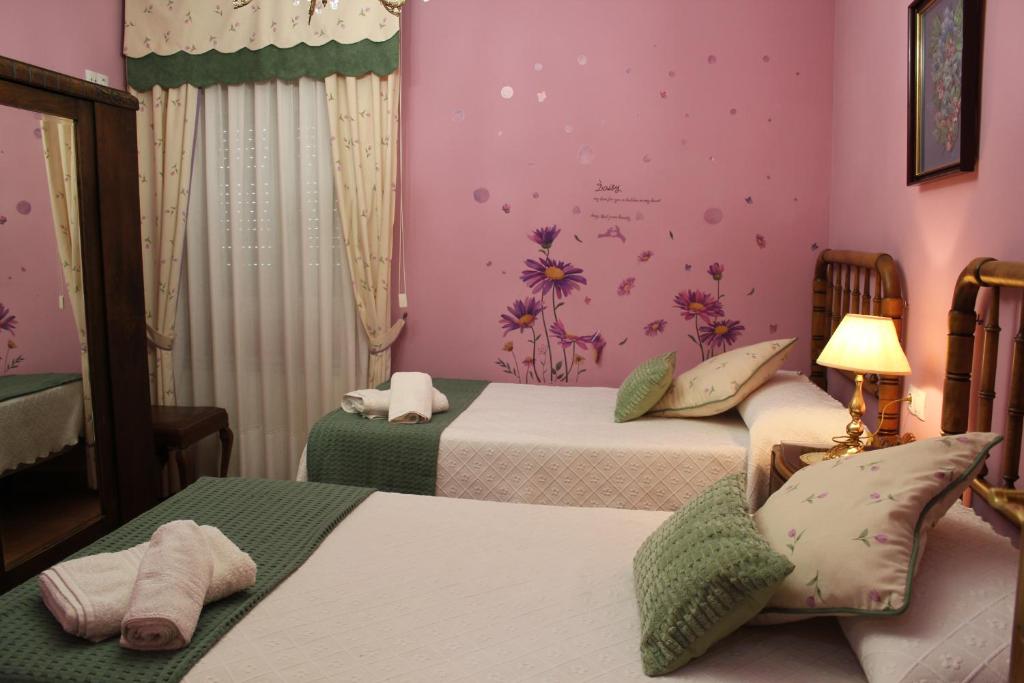 um quarto com 2 camas e uma parede rosa em La Cuadra em Cabornera