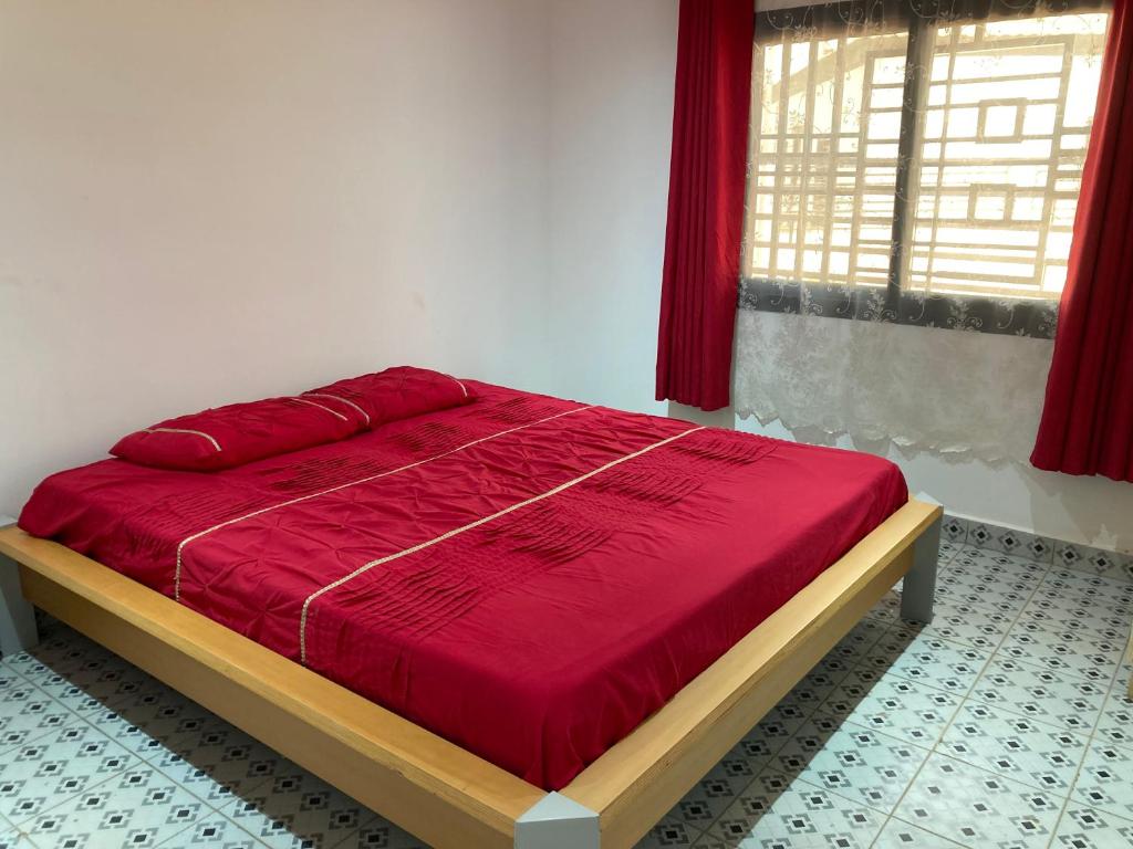 1 cama con edredón rojo en un dormitorio en Palm Villas Estate, en Bijilo