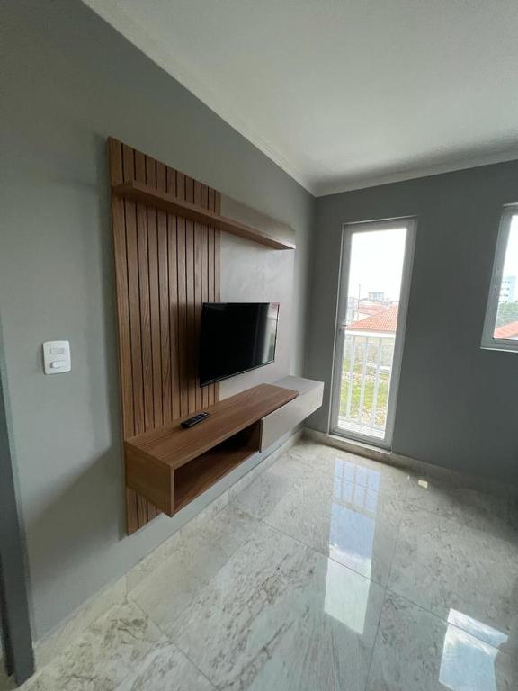 a living room with a flat screen tv on a wall at Residencial Cristina Pinto in Campina Grande