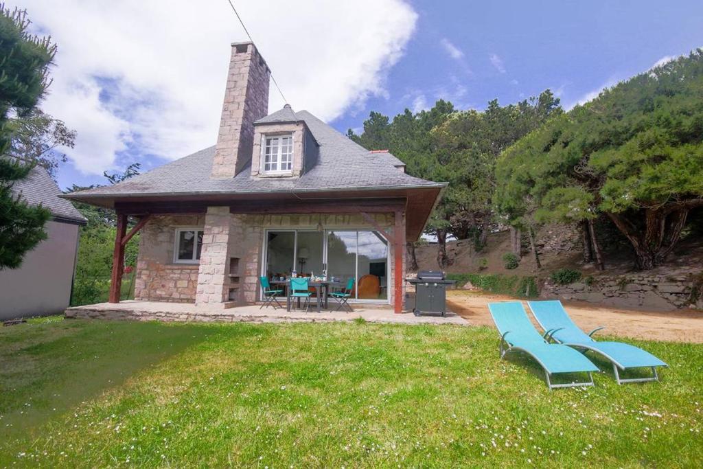 une maison avec un banc bleu dans la cour dans l'établissement 604 - Maison avec grand jardin calme et paisible proximité centre et plage d'Erquy, à Erquy
